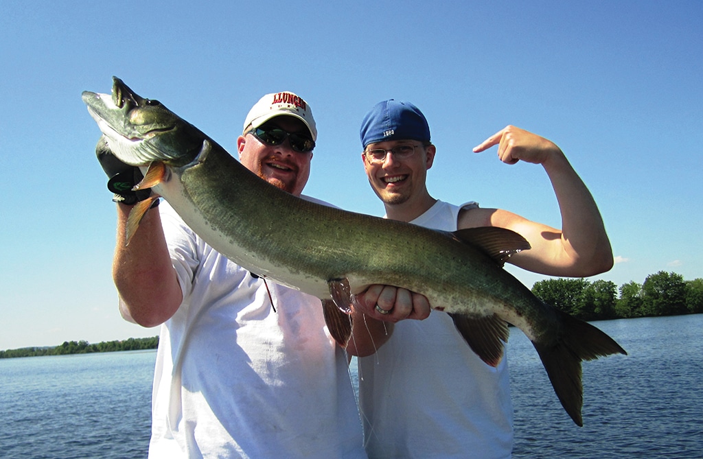 The author helps Nate Davidson celebrate his first musky.